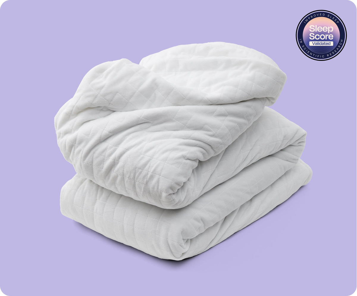 A folded white Gravity Original Weighted Blanket (10–25 lb) filled with glass beads, featuring a Sleep Score Validated seal in the upper corner.
