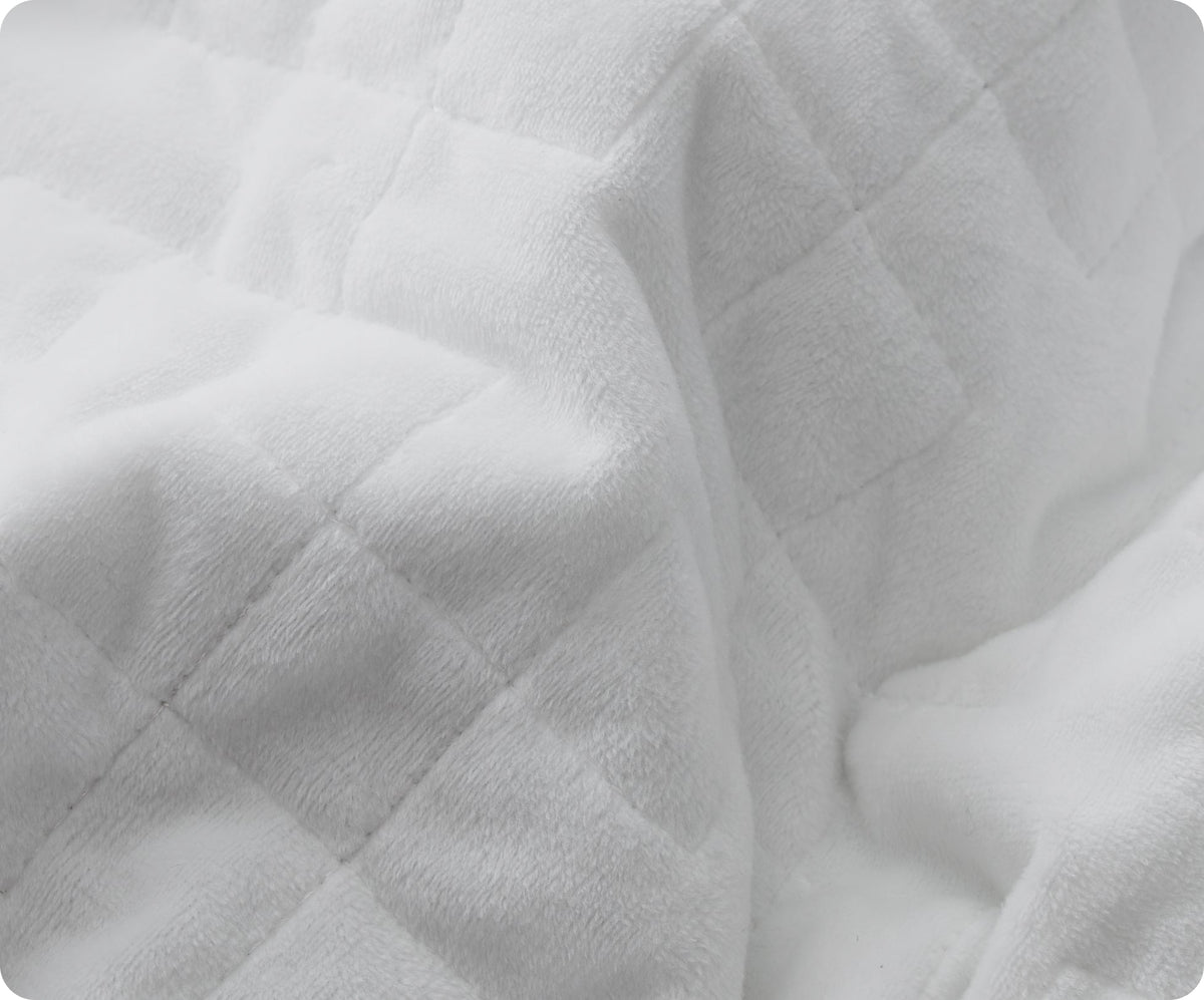 A close-up of a white, quilted-square Gravity Original Weighted Blanket featuring a breathable cover.