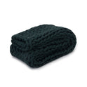 A neatly folded Knit Weighted Blanket in Forest Green with chunky braided yarn is displayed on a white background.