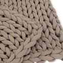Close-up of the Knit Weighted Blanket in light brown/taupe, showcasing thick, soft braided yarn and a large, intricate knit pattern for cozy, breathable comfort.