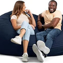 Two people sit comfortably on the Fuf XXL Foam Filled Bean Bag Chair in Cobalt, 6 Feet. Both are smiling, casually dressed in light shirts and jeans, looking relaxed and engaged with each other.