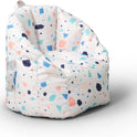 The Milano Kids Bean Bag Chair for Comfort and Fun has a high back, armrests, and a colorful geometric pattern in blue, pink, and orange shapes. Its versatile design brings both comfort and style to any playroom or bedroom.