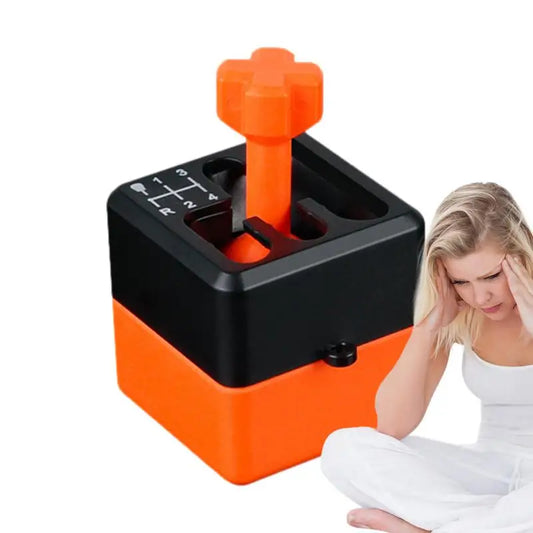A woman holding her head in discomfort sits next to a Manual Gear Shifter Keychain 3D Printed Fidget Toy Mood Enhancer, orange and black with a numbered plate. This chemical-free novelty offers soothing relief against a plain white background.