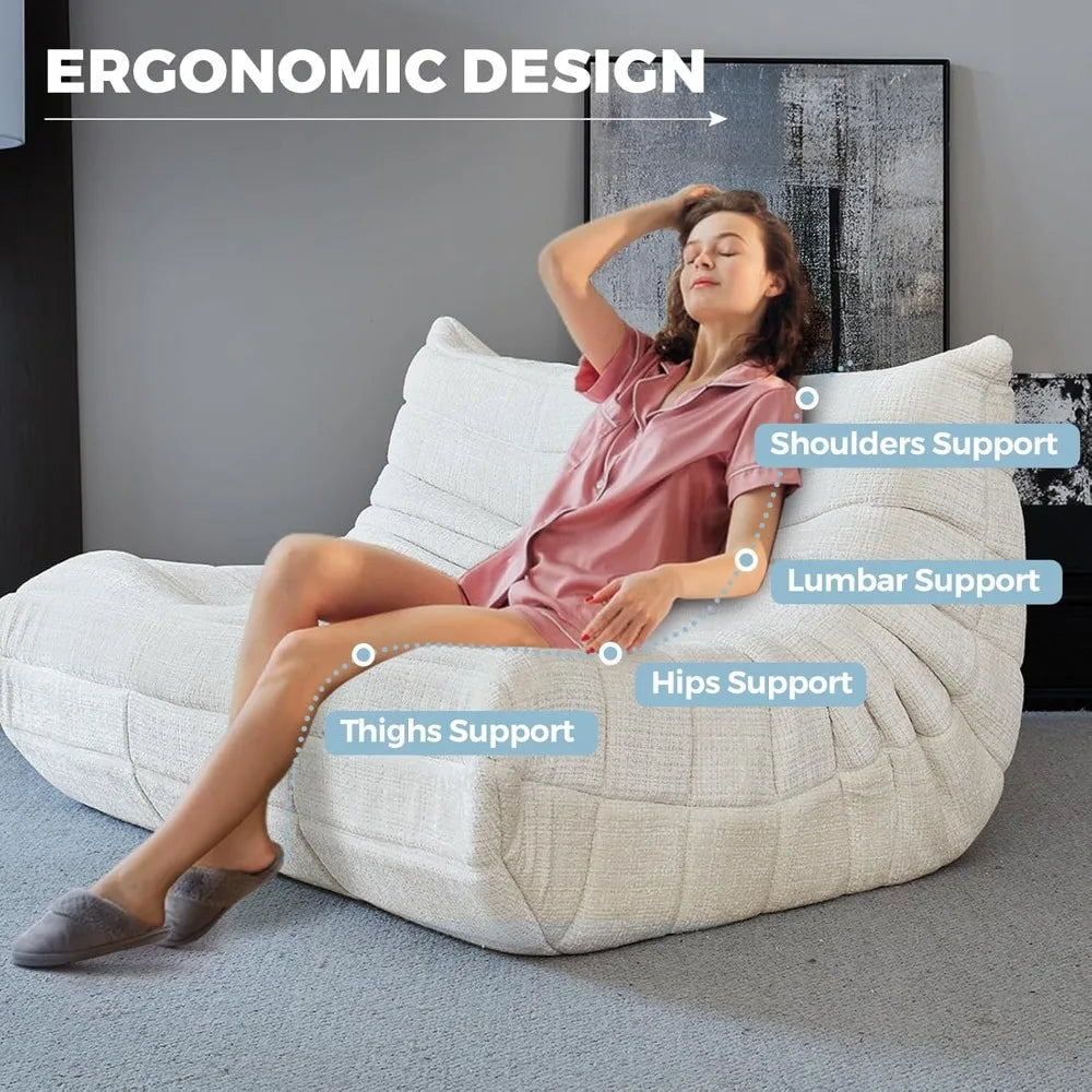 A woman in pajamas relaxes on the Fireside Loveseat Sofa Couch Modern Chenille Bean Bag Chair. Text highlights its ergonomic support for shoulders, lumbar, hips, and thighs. Ergonomic Design appears at the top.