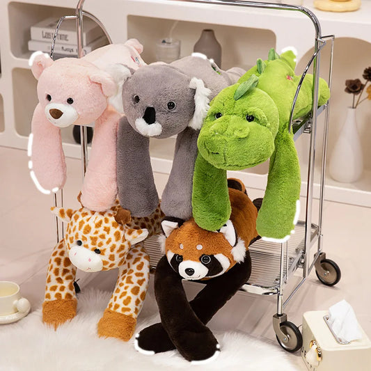 A metal cart holds Long Arm Animal Weighted Stuffed Animals—fluffy plush raccoon, koala, bear, giraffe—each with long limbs draped over the cart’s shelves in a cozy indoor setting.