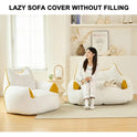 A woman in white relaxes on a large, cat-shaped Premium Teddy Velvet Bean Bag Sofa Cover for Indoor Lounging with yellow accents. A matching smaller cover is nearby in the cozy, book-filled room. Text above: “LAZY SOFA COVER WITHOUT FILLING.”.