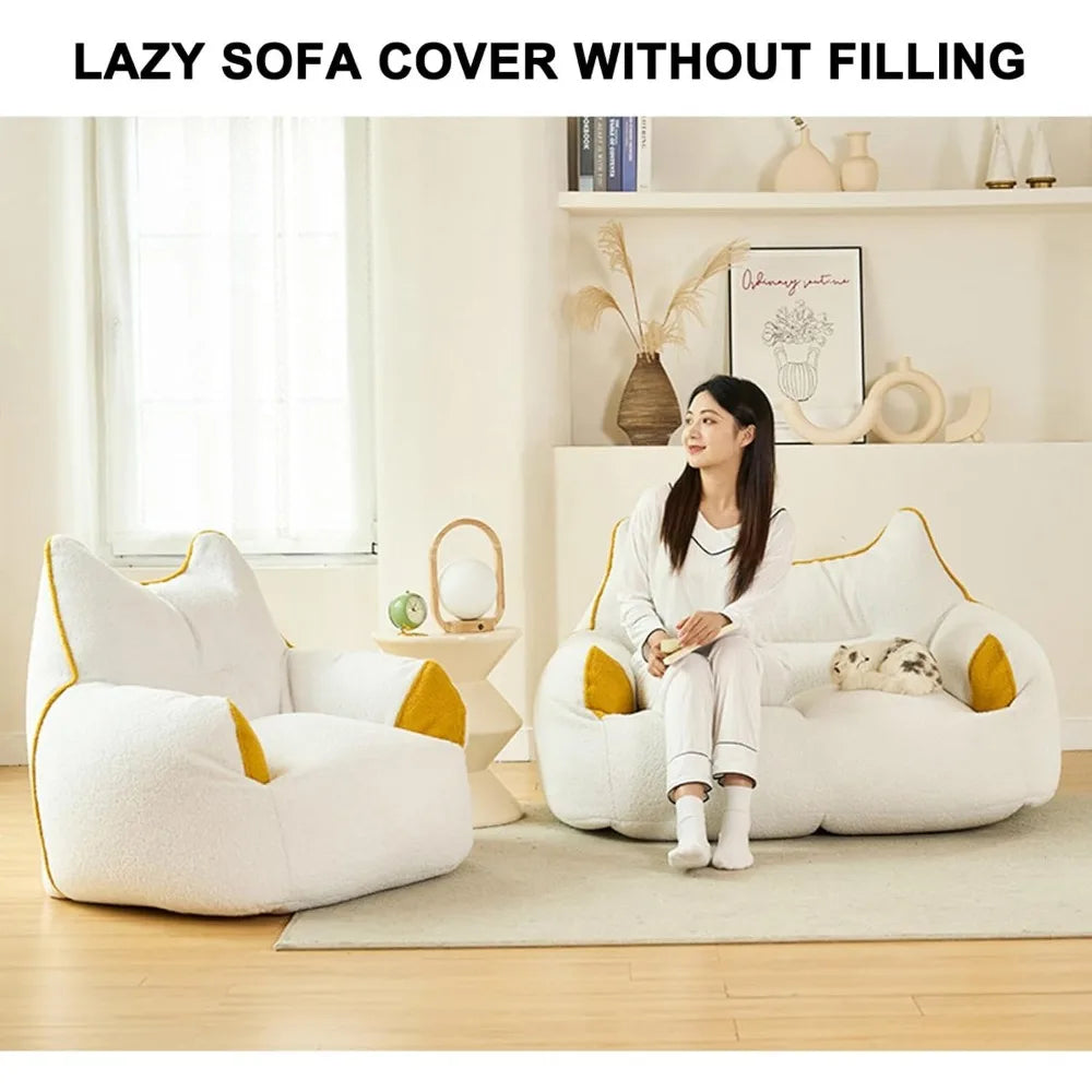 A woman in white relaxes on a large, cat-shaped Premium Teddy Velvet Bean Bag Sofa Cover for Indoor Lounging with yellow accents. A matching smaller cover is nearby in the cozy, book-filled room. Text above: “LAZY SOFA COVER WITHOUT FILLING.”.