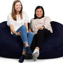 Two women sit comfortably on a Fuf XXL Foam Filled Bean Bag Chair, 6 feet, in Navy, smiling and relaxed against a plain white background.
