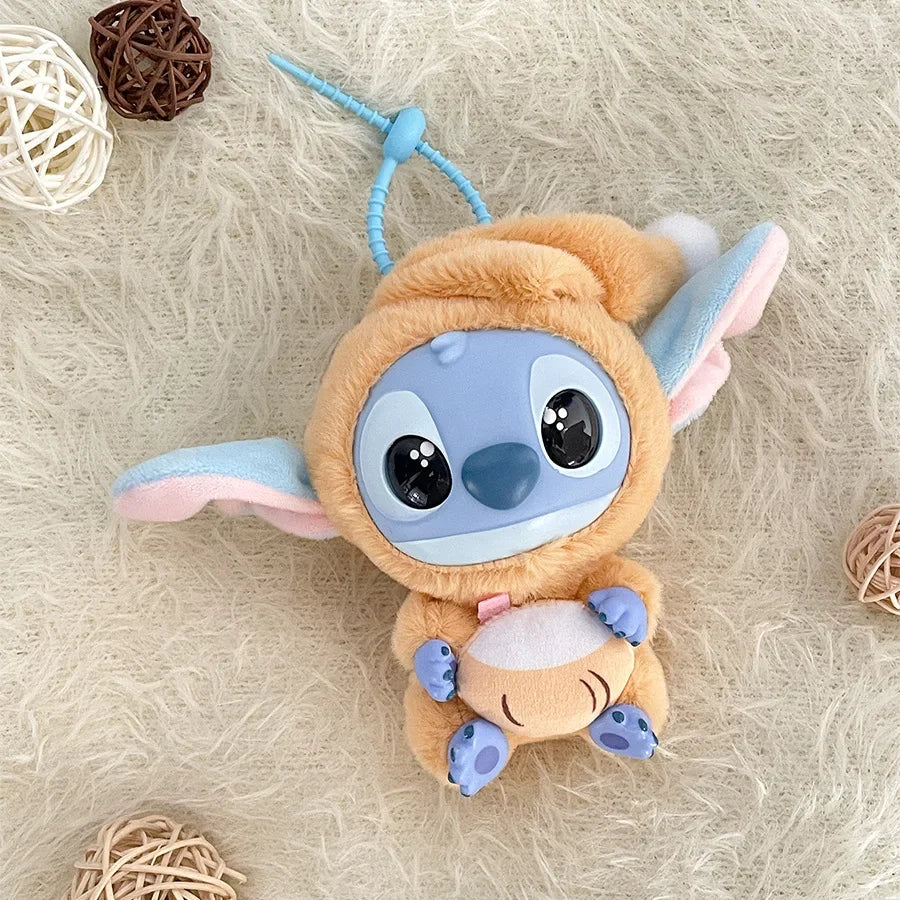 The Kawaii Accessories Stitch Plush Toy from the Eat Something Before Sleep series features a cute animal costume and pouch. This Lilo & Stitch keychain keyring doll makes a perfect backpack pendant for girls, displayed on a fluffy surface with wicker balls.