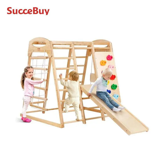 Three young children play on the SucceBuy Indoor Jungle Gym 7-in-1, a wooden toddler playground with slide, wood and rope ladders, and net ladder for ages 2-6. Set features light wood on a plain white background; SucceBuy logo at top left.