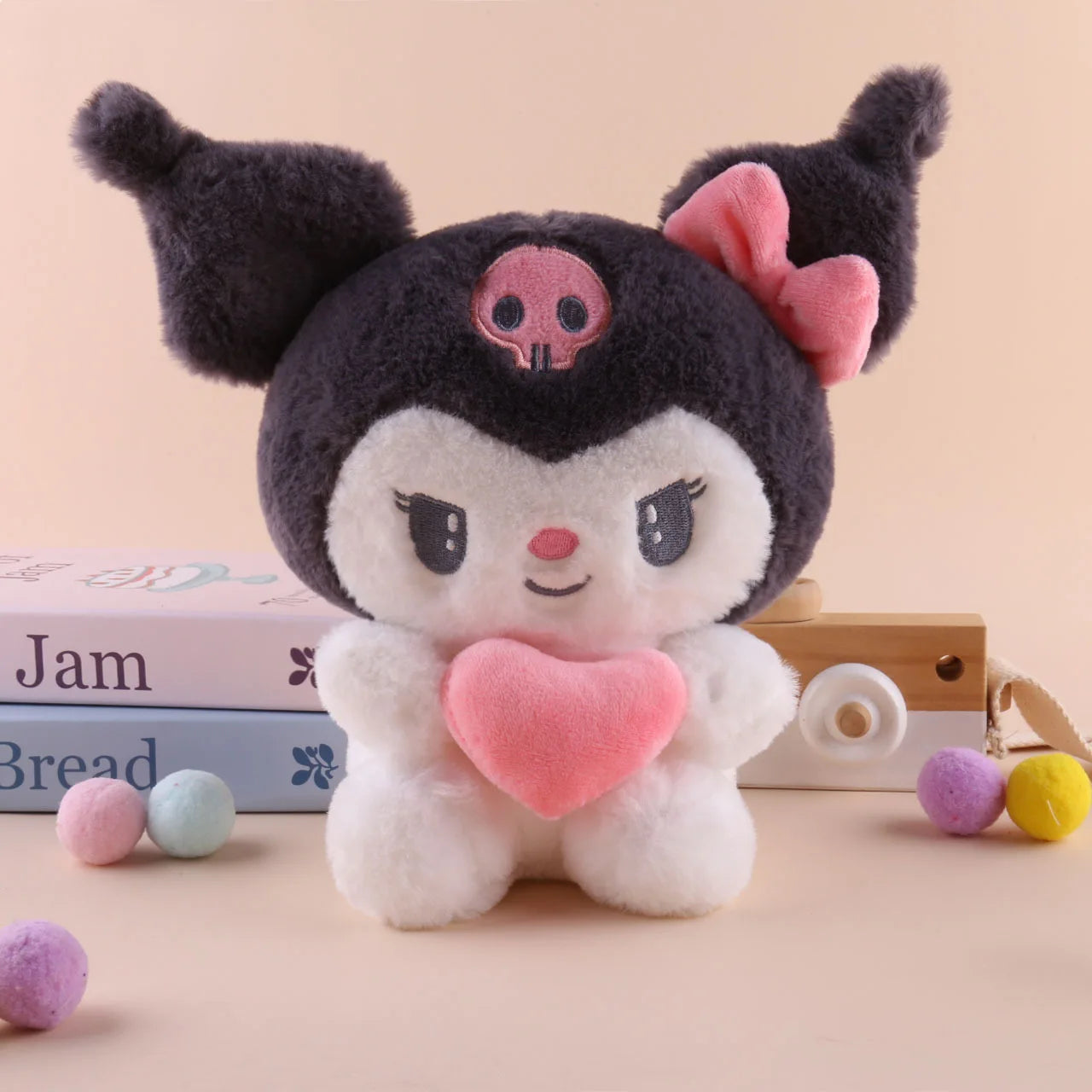 The 22cm Sanrio Hello Kitty Kuromi Pillow KT Plush Toy, a soft stuffed animal in Kuromi colors, features a black hood, pink bow, and pink skull emblem while holding a pink heart—perfect as a cute gift for girls.