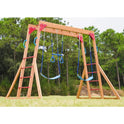 The Wood Swing Sets for Backyard with Monkey Bar Playset features two blue swings, gymnastic rings, red handles, ladders on both sides, and monkey bars—perfect outdoor play equipment for kids to enjoy among trees and grass.