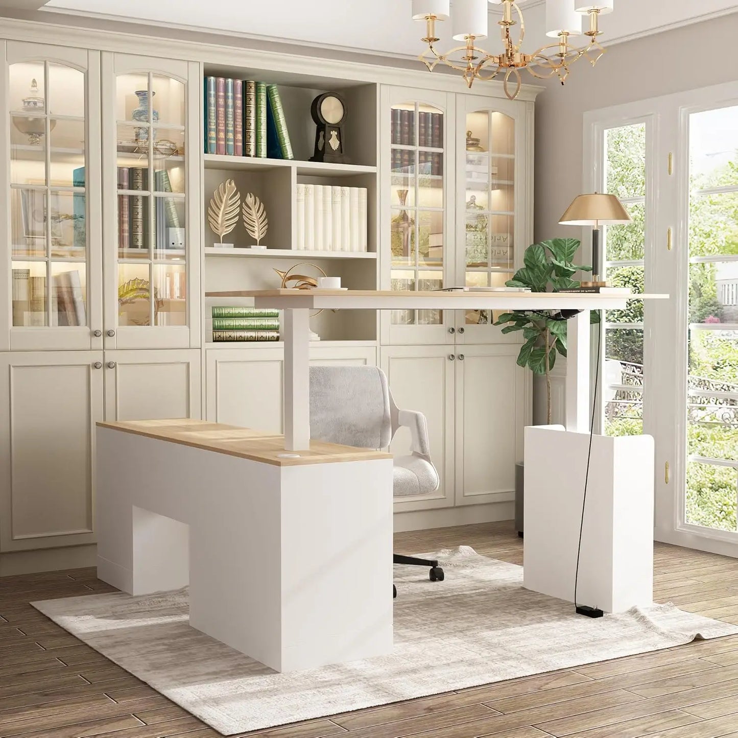 A bright, modern home office with a walnut and white L Shaped Electric Standing Desk with Drawers and Shelves, an ergonomic chair, a glass-door bookshelf, a lamp, and natural light streaming onto a light rug.