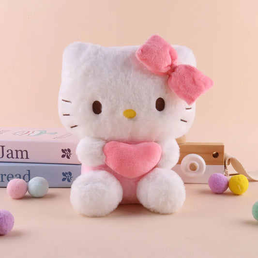 The 22cm Sanrio Hello Kitty Kuromi Pillow KT Plush Toy, a soft stuffed animal gift for girls, features Hello Kitty with a pink bow and heart, shown in front of pastel books and candies on a light beige background.