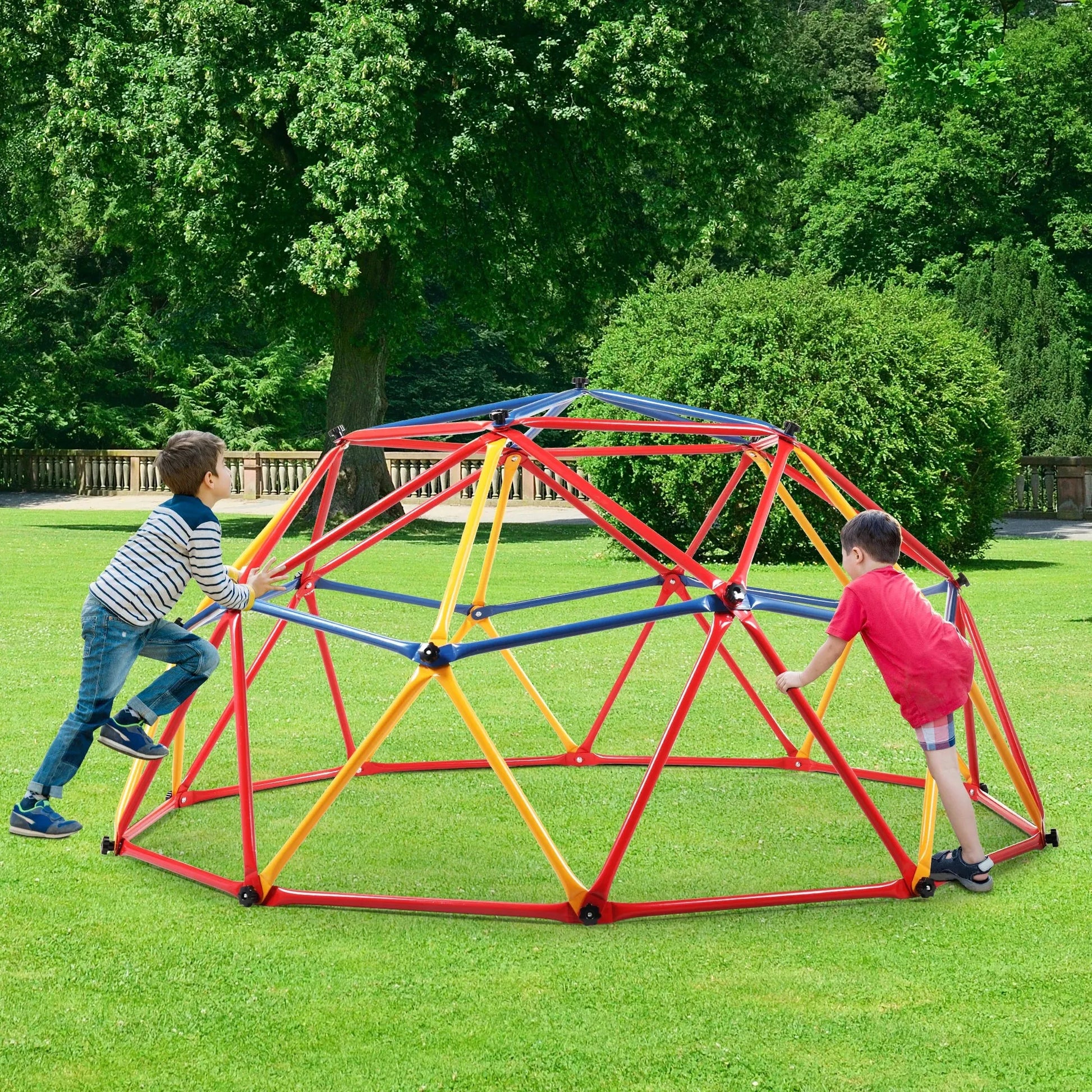 Two children enjoy the Kids Outdoor Climbing Dome, a vibrant geometric metal structure in a grassy park. One, wearing a striped shirt and jeans, climbs while the other in a red shirt and shorts stands on the opposite side amidst lush greenery.