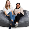 Two women sit and smile together on the Fuf XXL Foam Filled Bean Bag Chair in grey, 6 feet long, against a white background.