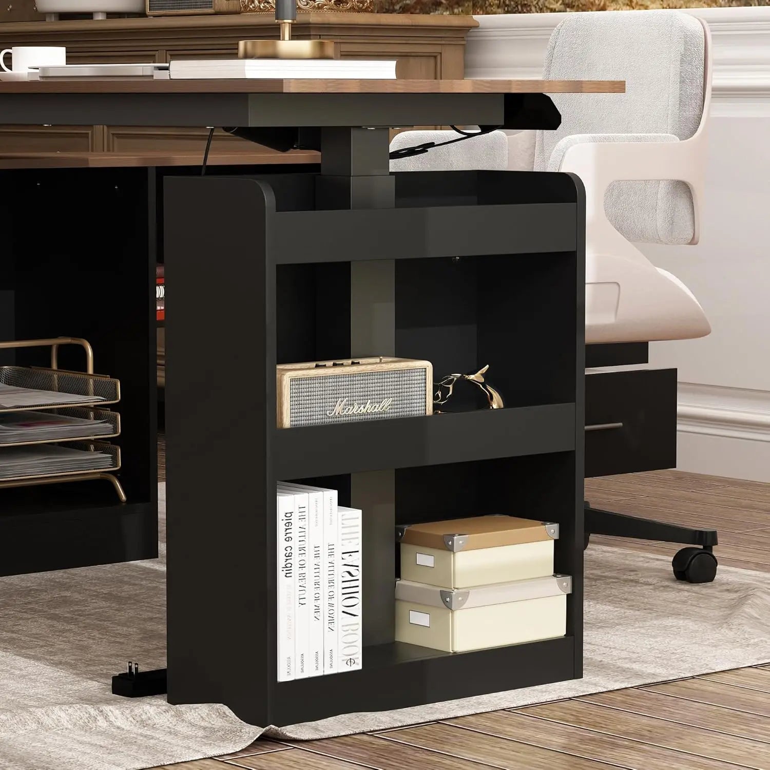 A modern black bookshelf under an L Shaped Electric Standing Desk with Drawers and Shelves displays a Marshall speaker, camera, books, and storage boxes. Nearby is a white wheeled office chair, with part of a stylish wooden office in view.