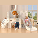 Three children play indoors on the Beige Grey 8 In 1 Toddler Slide Set With Basketball Hoop For Kids. One climbs, another prepares to shoot a basketball, and a third slides down as sunlight shines through large windows behind them.
