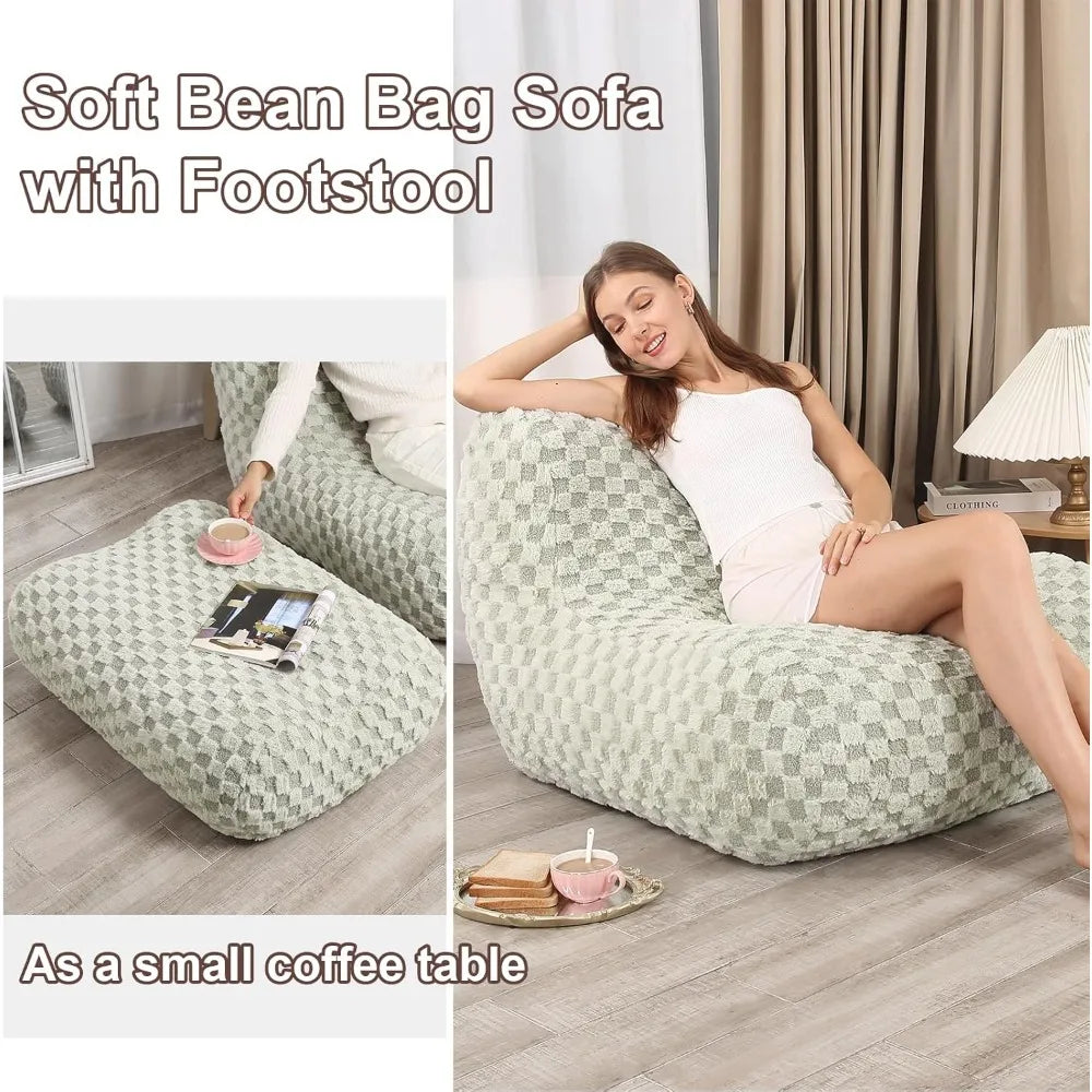 A woman relaxes on the Bean Bag Sofa, a comfy reading sofa chair for adults with a matching footstool used as a coffee table for her cup, book, and plate. Perfect modern floor sofa for living room & bedroom.
