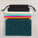 A Children’s Puzzle Silicone Sensory Activity Board (food grade, BPA free) with textured teal grooves is placed below colorful silicone drinking straws and a black drawstring pouch on a light wooden surface.