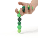 A hand holds textured green balls—part of the 4Pcs 8PCS Silicone Magnetic Balls Set for Adults—unique silicone fidget toys designed to calm restless hands and an anxious mind, shown against a white background.