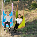 Two young children enjoy the outdoors on sensory swings. The child on the right sits happily in a green Kids Pod Swing Seat Bag Sensory Swing Portable Hammock Chair Inflatable Swing With Cushion, surrounded by grass and trees.