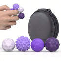 A hand holds a silicone magnetic ball from the 4Pcs PURPLE set for adults, with three more balls placed near a round black zippered carrying case.