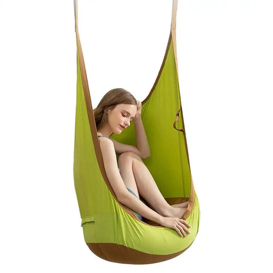 A young woman sits relaxed in the Kids Pod Swing Seat Bag Sensory Swing Portable Hammock Chair with cushion, legs folded and hand on her head, against a plain white background.