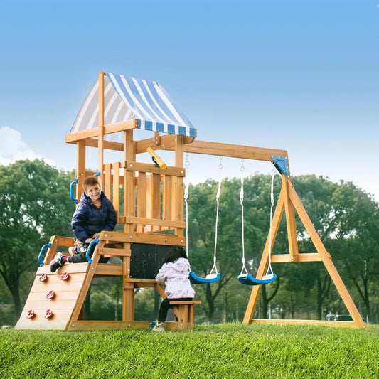 Two children play on the Wooden Swing Set for Backyard - All-in-One Kids Playset with swings, slide, and climbing wall under a green canopy—ideal outdoor play equipment for any backyard playground, surrounded by grass and trees.