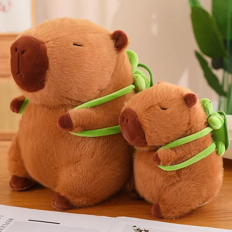 Two Cute Turtle Backpack Capibara Strawberry Hat Capybara Plush Toys sit side by side on a wooden surface, with a blurred green plant behind—adorable stuffed animals and the perfect birthday gift or decor for kids.