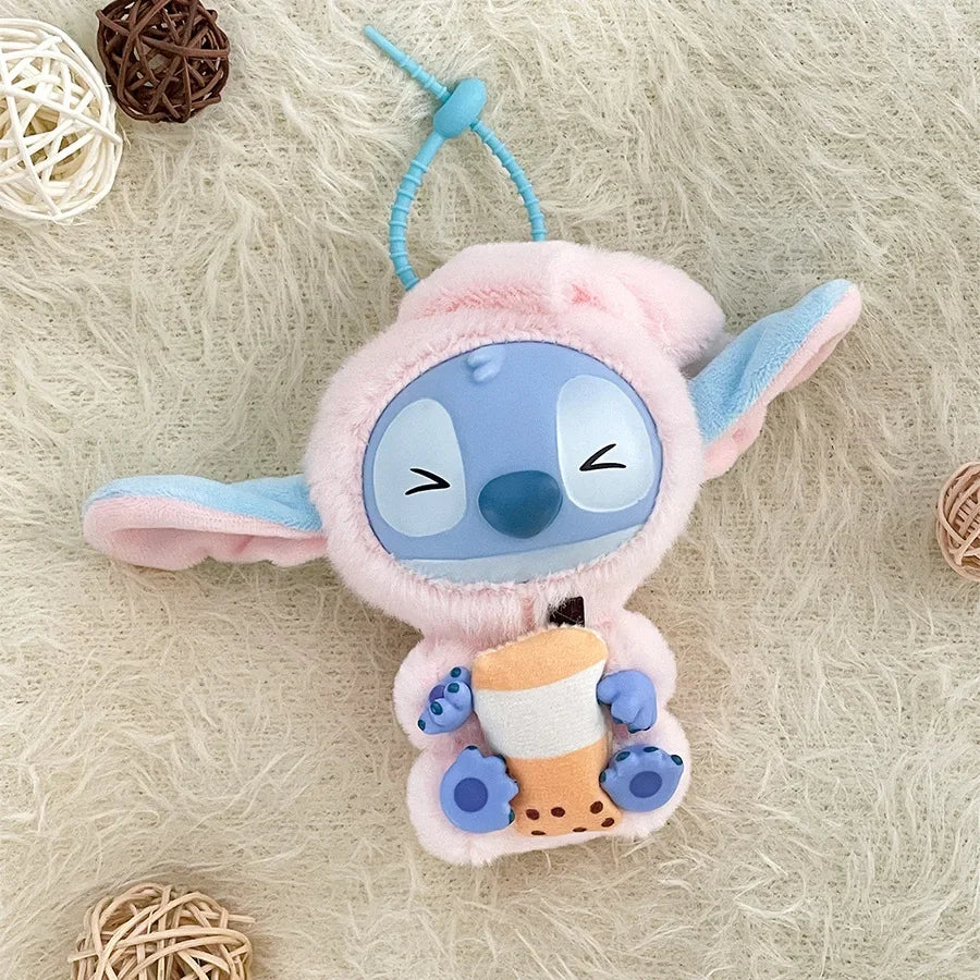 The Kawaii Accessories Stitch Plush Toy Lilo and Stitch Keychain features a light blue and pink Stitch holding bubble tea, perfect as a cute backpack pendant or keyring for girls. It sits on a fluffy cream surface with wicker ball decorations.