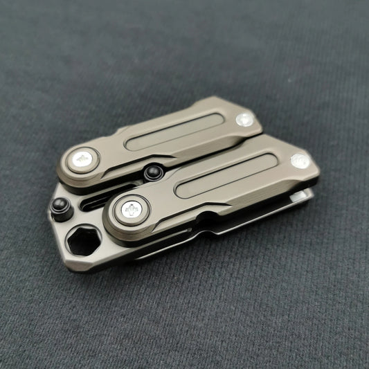 A compact Fidget Magnetic Coin EDC Decompression Toy with a metallic gray finish and visible screws, showcasing its multifunctional crowbar slider spinner design, rests on a dark textured surface.
