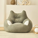 A Premium Teddy Velvet Bean Bag Sofa Cover for Indoor Lounging, in plush light green with cat ear and paw designs, adds a cozy touch to a modern minimalist room with light walls, wood floor, and shelf decor.