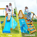 Three kids enjoy the Playground Swing Sets for Backyard, a wooden playset with 2 swings, a big blue wave slide on the left, and a climbing wall with colorful holds on the right—fun dinosaur designs complement your outdoor space.