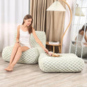 A woman in white relaxes on the Bean Bag Sofa with Footstool— a comfy reading sofa chair for adults— with a tray and cup on the ottoman. A floor lamp and large mirror add to this cozy, modern living room or bedroom retreat.