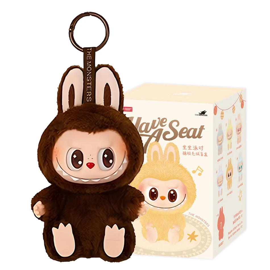 The Cute Labubu The Monsters Box Toy Sweetheart Vinyl Doll in Style D with box is a plush keychain featuring large eyes, red cheeks, and bunny ears—perfect as a kawaii backpack pendant or for PVC figure collectors.