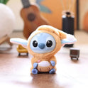 A Kawaii Accessories Stitch Plush Toy (Color: C) from the Eat Something Before Sleep Series sits on a wooden surface, with a blurred guitar and other accessories in the background. Perfect as a keychain, keyring doll, or backpack pendant for girls.