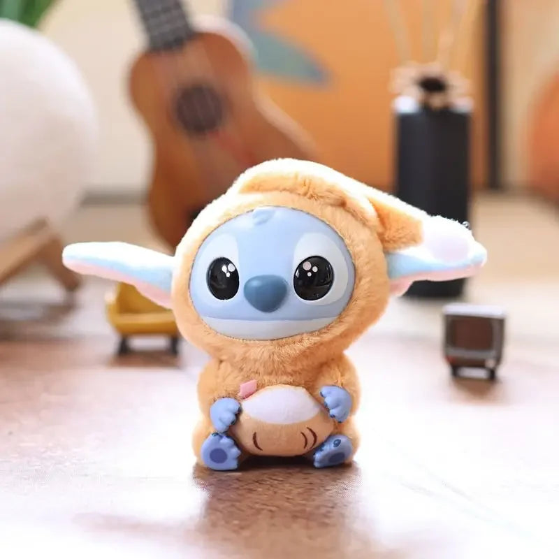 A Kawaii Accessories Stitch Plush Toy (Color: C) from the Eat Something Before Sleep Series sits on a wooden surface, with a blurred guitar and other accessories in the background. Perfect as a keychain, keyring doll, or backpack pendant for girls.