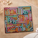 The Silicone Montessori Sensory Activity Board Fidget Toy for Kids features a colorful abstract maze with wavy paths in pink, yellow, orange, white, and turquoise on a brown base—perfect for anxiety relief and mindfulness.