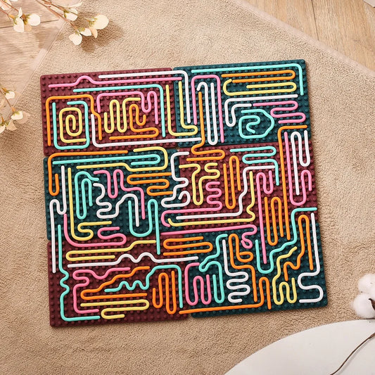 The Silicone Montessori Sensory Activity Board Fidget Toy for Kids features a colorful abstract maze with wavy paths in pink, yellow, orange, white, and turquoise on a brown base—perfect for anxiety relief and mindfulness.