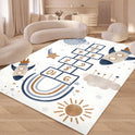 A modern living room features soft, curved furniture and the Hopscotch Printing Carpet, a washable, non-slip rug with playful designs like rockets, clouds, and stars in neutral and blue tones. Light streams through large windows.