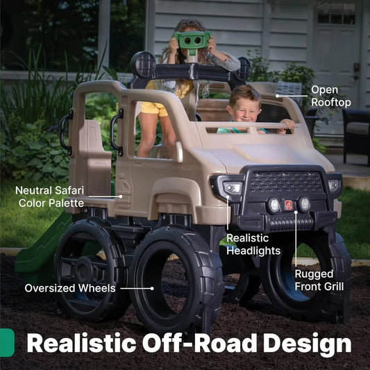 Two children enjoy the tan, safari-themed Truck Climber Kids Outdoor Playset with Slide and Wall—one child uses binoculars while the other steers from the driver’s seat among its oversized wheels and open rooftop.