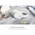 A pair of WH-CH720N Wireless Bluetooth Headphones with Noise Canceling, 35H battery, and built-in mic sits on a gray surface beside a gold ring, lipstick, and perfume. Spanish text highlights clear sound and headphone customization.