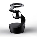 A modern black sculpture with a spiraling design holds a reflective sphere, reminiscent of the Kinetic Alloy Fidget Spinner - Stress Relief Desk Toy, on a round base against a white background.