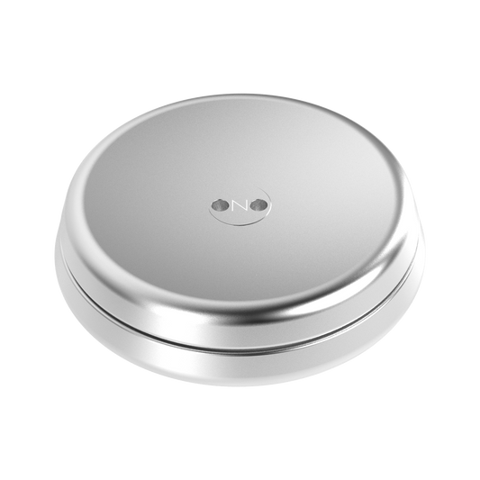 A round, silver ONO Slider Aluminum container with a smooth, flat lid featuring a subtle embossed logo and two central indents—ideal for storing your calming fidget toy or ONO Slider magnetized disks.