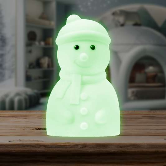 Stanley the Snowman Mini Night Light glowing green on a wooden surface.