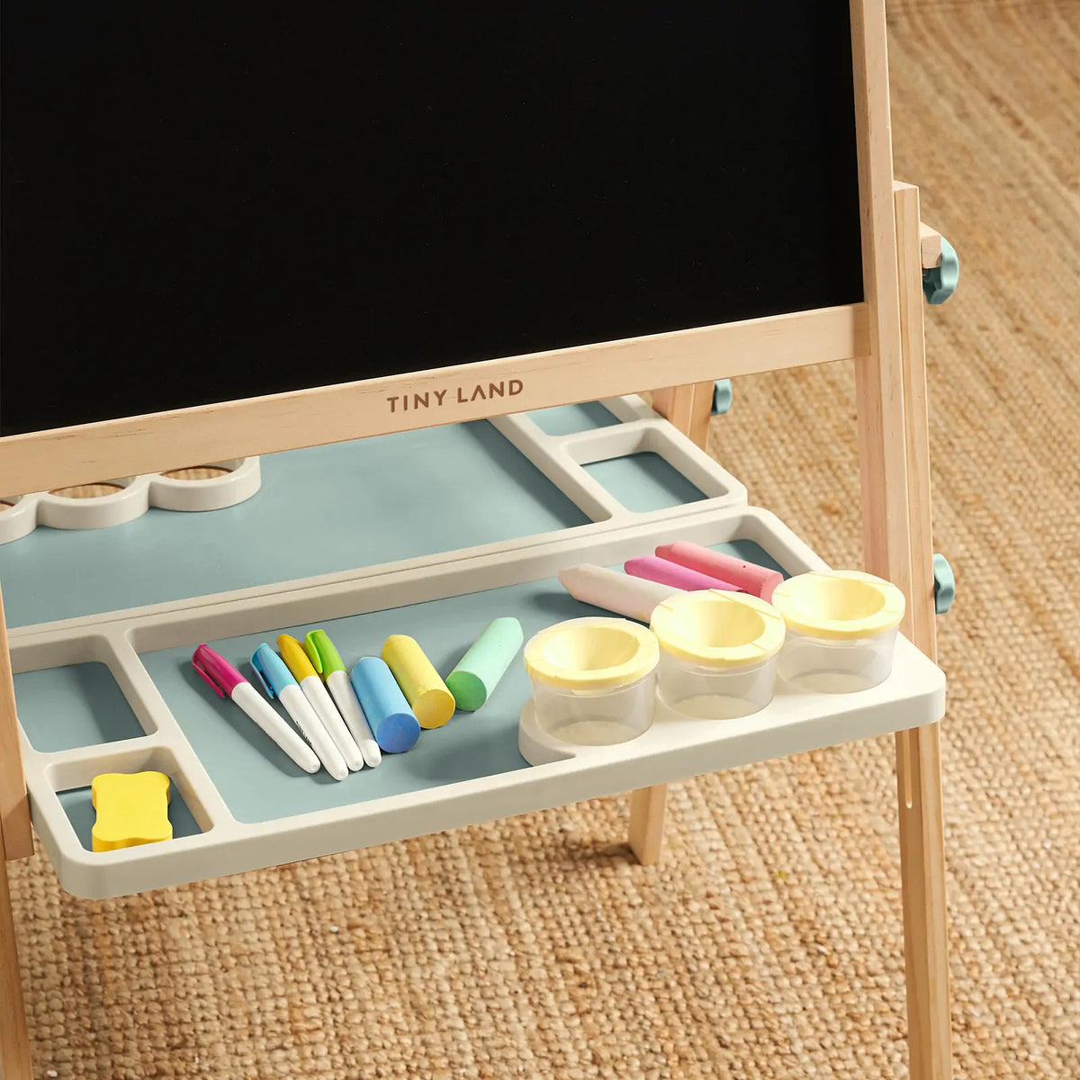 Magnitales Double-Sided Art Easel with Paper Roll featuring a magnetic whiteboard and chalkboard, with a storage tray holding markers, chalk, and three paint cups.