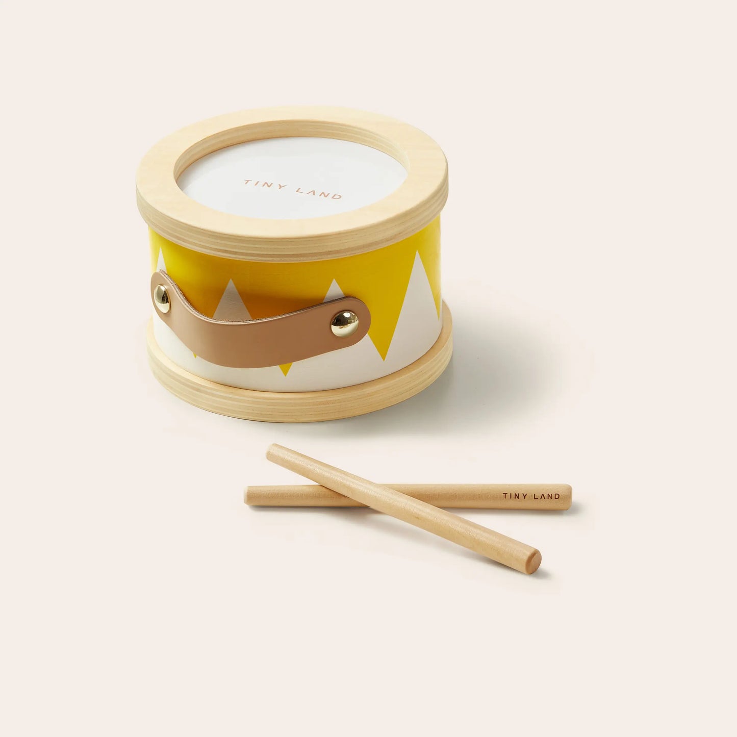The Tiny Land® Montessori Toys for Toddlers (13–15 Months) features a small toy drum with a yellow and white pattern, wooden rim, brown handle, and includes two wooden drumsticks—perfect as an educational toy.