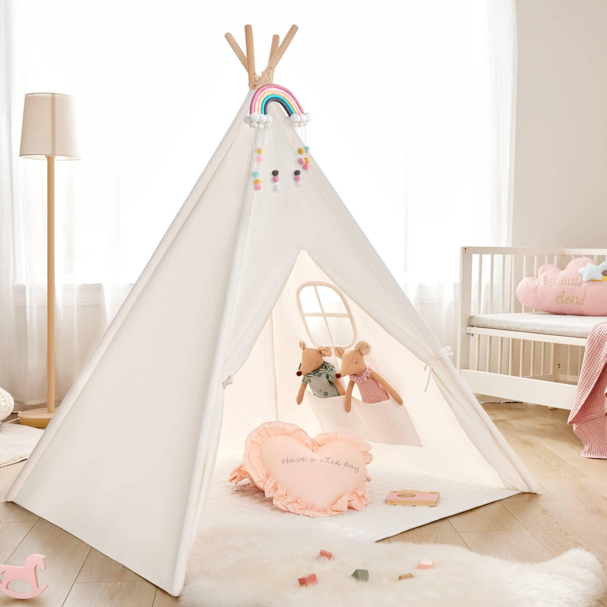 Cozy Kids Teepee Tent with Padded Mat featuring a white canvas design with a rainbow above the entrance, two stuffed mice toys, and a heart-shaped pillow on the floor.