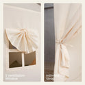 Light-colored window on a Large Cozy Cabin Play Tent with Star Lights, featuring a roll-up shade and a curtain held back by a tie to create a cozy reading nook.